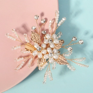 Gros plan détaillé d'une barrette de mariée avec perles blanches et feuilles dorées