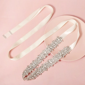 Dettaglio della cintura da sposa in raso avorio con lussuosi motivi floreali in strass
