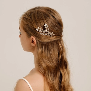 Detailed close-up of a bridal hair comb with marquise rhinestones on a gold leaf base