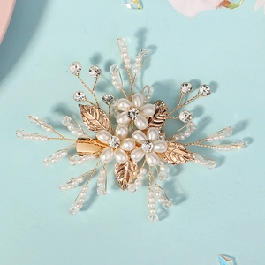 Détail de la pince à cheveux de mariée avec fleurs en perles et feuilles de cristal
