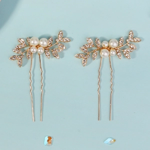 Detailed view of handmade bridal hair pins with gold leaves, pearls and rhinestones