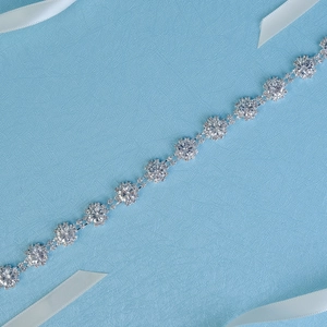 Détail d'une ceinture chaîne florale argentée avec strass scintillants et motifs tournesol