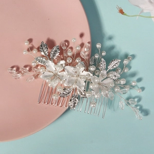 Handmade bridal hair comb with silver flowers, pearls and crystals on blue background