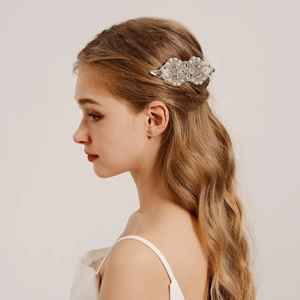 Close-up of bridal hair comb with rhinestones and pearls on model's hairstyle