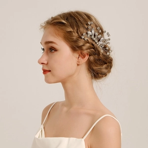 Detail of bridal hair comb with silver leaves and rhinestones worn on a bride