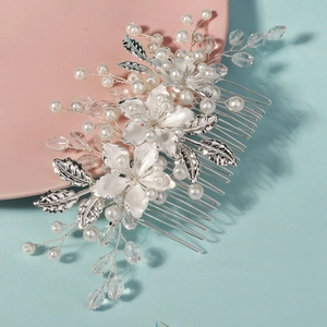 Detailed close-up of handmade bridal hair comb with silver flowers, pearls and crystals