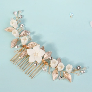 Dettaglio del pettine da sposa fatto a mano con petali in ceramica e foglie dorate