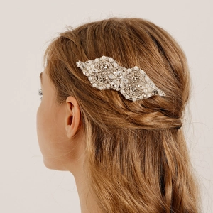 Detailed view of handmade silver hair comb with rhinestones and pearls on bridal hair