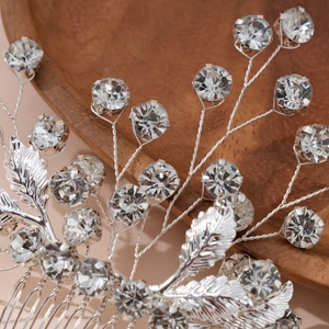 Macro detail of handmade silver bridal hair comb with rhinestones and leaf motifs