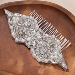 Exquisite bridal hair comb with pearls and rhinestones on a wooden tray, 45-degree view