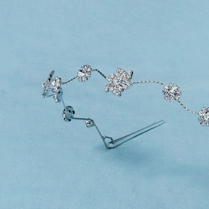 Détail d'un peigne à cheveux argenté avec motifs floraux et cristaux brillants