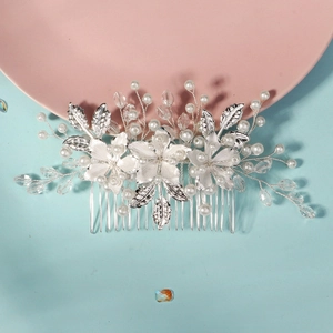Detailed close-up of handmade bridal hair comb with silver flowers, pearls and crystals