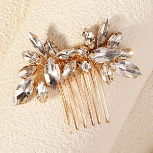 Close-up of luxury bridal hair comb with marquise crystals and golden alloy floral cluster