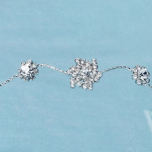 Gros plan d'un bandeau de mariée en argent avec flocon de neige en cristal et motifs floraux