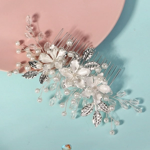 Detail of silver bridal hair comb with handmade white flowers and intricate pearl beading