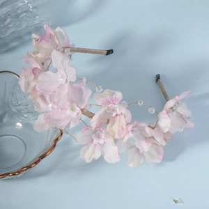 Detail of pink silk flowers and crystal beads on a handmade bridal floral headband