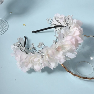 Detailed close-up of handmade fabric rose headband with crystal beads for bridal party