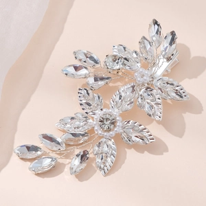 Detail of silver bridal hair clip with crystal flowers and pearls on silk