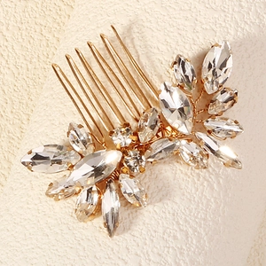 Macro detail of gold bridal hair comb with sparkling marquise rhinestones and flower motif