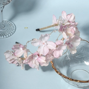 Detail of handmade fabric floral headband with pink petals and white bead centers