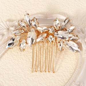 Macro detail of luxury gold bridal hair comb with marquise and round rhinestones