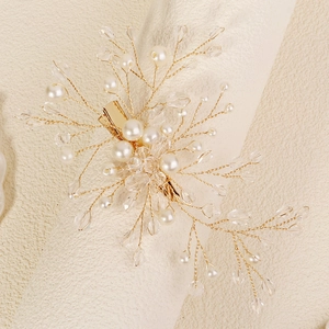 Macro shot of handmade gold wire hair clip featuring white pearls and clear crystals