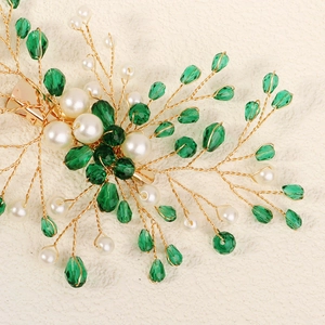Detail of bridal hair clip with green crystal beads and white pearls on gold wire