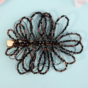 Detailed macro view of handmade black crystal beaded hair clip on a golden metal base