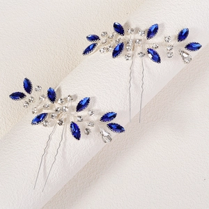 Detail of bridal hair pins with blue marquise rhinestones and silver leaf branch design