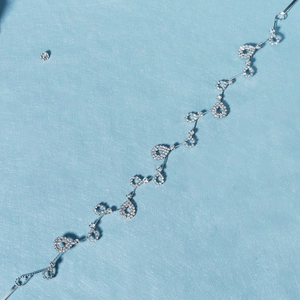 Détail d'un bandeau de mariée argenté orné de cristaux en forme de gouttes et ronds