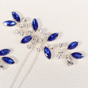 Close-up of handmade bridal hair pins with blue marquise rhinestones and silver wire