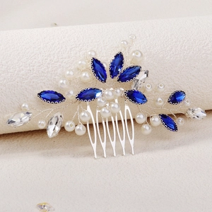Detailed close-up of bridal hair comb with blue marquise gems, crystals and white pearls