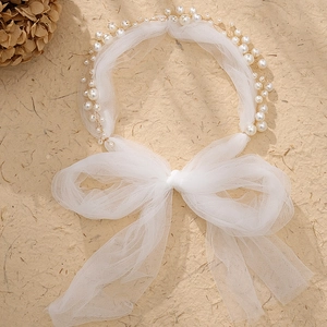 Detail of bridal headband featuring layered white tulle, pearls, and an elegant mesh bow