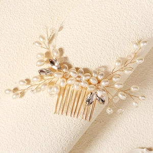 Detailed close-up of handmade bridal hair comb with pearls and crystals on gold wire