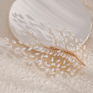 Detail of gold floral bridal hair comb with elegant white pearls and intricate wire wrapping