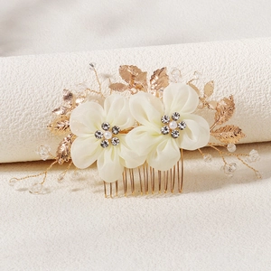 Detail view of handmade bridal hair comb with silk flowers, crystals and gold leaves