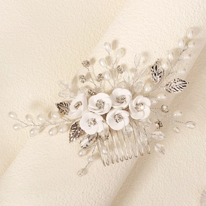 Detail of bridal hair comb with handmade white flowers, pearls, and crystals on silver wire