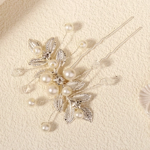 Détail de l'épingle à cheveux de mariée argentée avec feuilles, perles et strass brillants