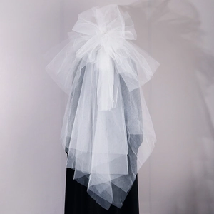 Detailed back view of a multi-layer white organza bridal veil with a large 3D bow design