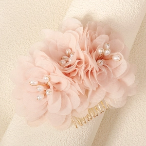 Detailed close-up of pink organza flower hair comb with pearls and golden wires