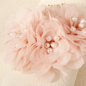 Detailed macro view of soft pink tulle floral hair comb with delicate white pearls
