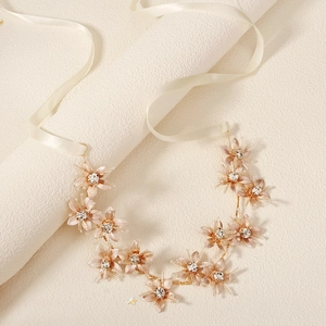 Détail d'un bandeau de mariée fleurs dorées à la main avec cristaux et ruban de soie ivoire