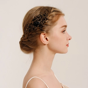Detailed close-up of a handmade black pearl hair comb styled on an elegant braided updo