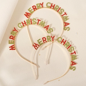 Close-up of three gold metal Merry Christmas headbands with red and green rhinestones