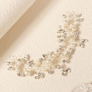 Detail of handmade bridal headband with white pearls and sparkling crystal vine pattern