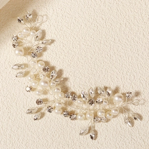 Close-up of hand-woven bridal hair vine with crystals and imitation pearls on silver wire