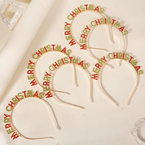 Detailed macro view of the golden Merry Christmas metal headband with red and green rhinestones