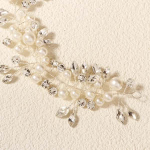 Detail of bridal hair vine with crystal rhinestones and white pearls on silver wire