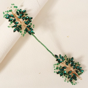 Detail of emerald green crystal leaf headband with gold wire woven beaded design