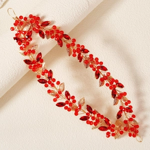 Close-up of handmade red rhinestone bridal headband with gold leaf details and crystal beads
